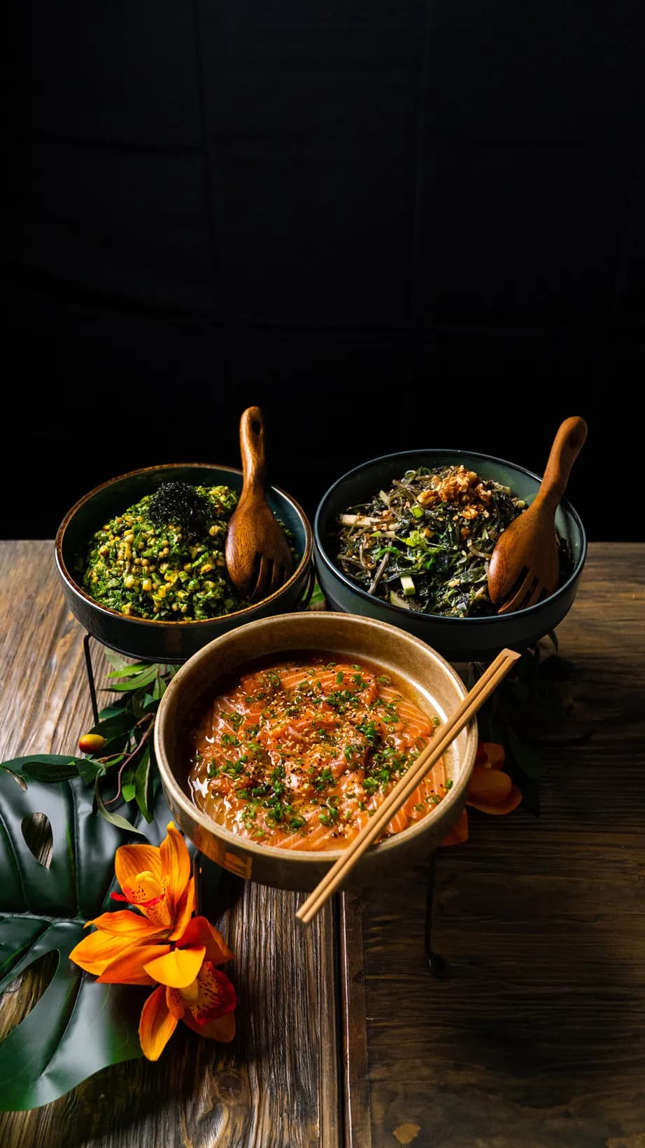 Catering by 3Fils — three handcrafted bowls of contemporary Asian cuisine on a rustic dark table